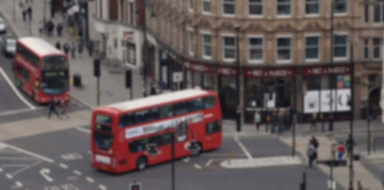 Red double-decker buses on a busy central London street