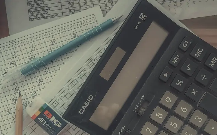 A calculator and handwritten sums